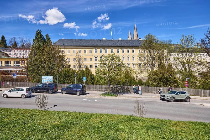 Royal Castle Berchtesgaden, general development, lawn, parking lane with vehicles, wooden fence, trees, pedestrians as secondary motif, blue sky, cumulus clouds, cirrostratus clouds, Am Fischerbichl, Bahnhofstraße, Berchtesgaden, Upper Bavaria, district Berchtesgadener Land, Bavaria, Germany
