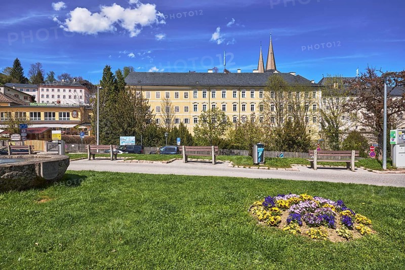 Royal Castle Berchtesgaden, general architecture, benches, lantern, lawn, trees, wooden fence, parking strip with vehicles, flower bed, garden pansy (Viola ×wittrockiana), blue sky, cumulus clouds, cirrostratus clouds, Am Fischerbichl, Bahnhofstraße, Berchtesgaden, Upper Bavaria, district Berchtesgadener Land, Bavaria, Germany