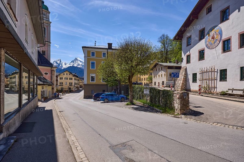 General architecture, historical building, sundial, quarry stone wall, parking boxes, vehicles, trees, light-flooded foliage, mountain landscape, mountain, blue sky, cirrostratus clouds, crossing Nonntal with town hall square, Berchtesgaden, Upper Bavaria, district Berchtesgadener Land, Bavaria, Germany