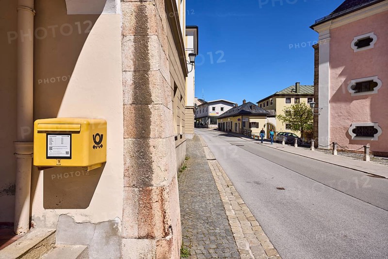 General architecture, letterbox, Deutsche Post AG, facade, pavement, cobblestones, street, asphalt, tree, pedestrian as secondary motif, blue sky, cloudless, town hall square, Berchtesgaden, Upper Bavaria, district of Berchtesgadener Land, Bavaria, Germany