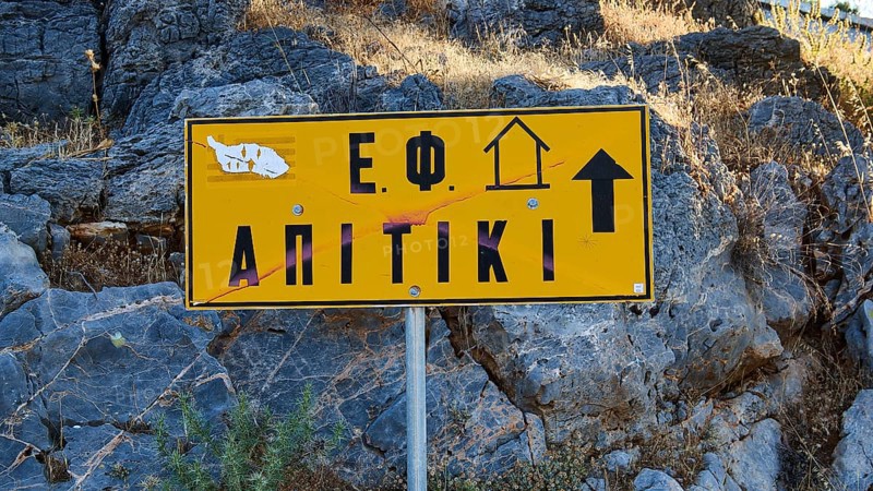 Apitiki, Bunker, Yellow sign with Greek inscription and arrow in front of a rock face, Photos related to WW2, Battle of Leros, Leros, Dodecanese, Greek Islands, Greece