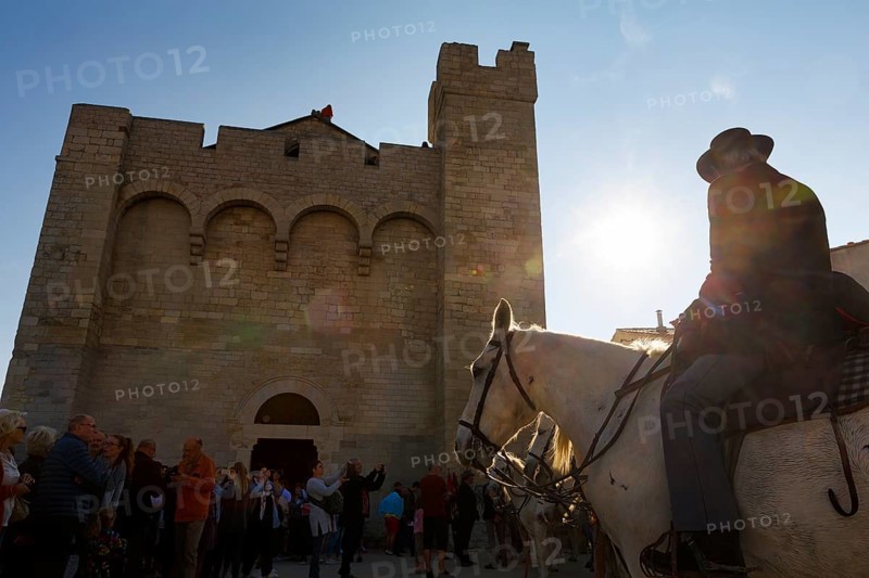 Guardian of the Camargue, rider on Camargue horse in front of the church, sunbeams, backlight, pilgrimage, procession in Saintes-Maries-de-la-Mer, Camargue, France