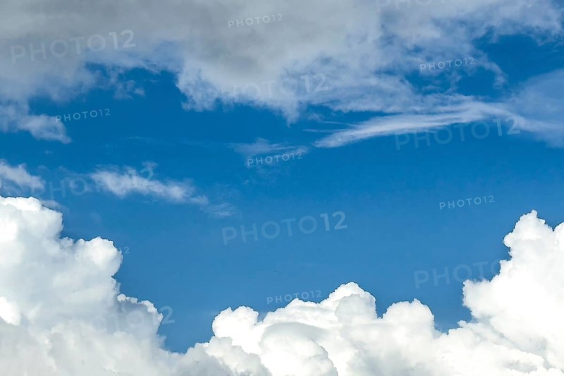 Below white cumulus clouds Cumulus clouds above grey stratocumulus framing blue sky, international