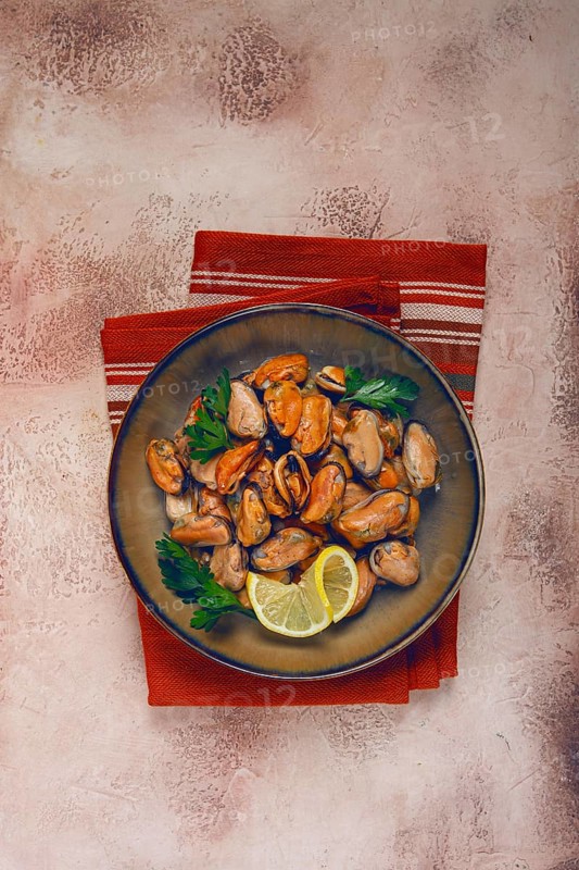 Mussels no shell, boiled, mussels, peeled, in a bowl, with lemon and parsley, Chilean mussels, top view, no people