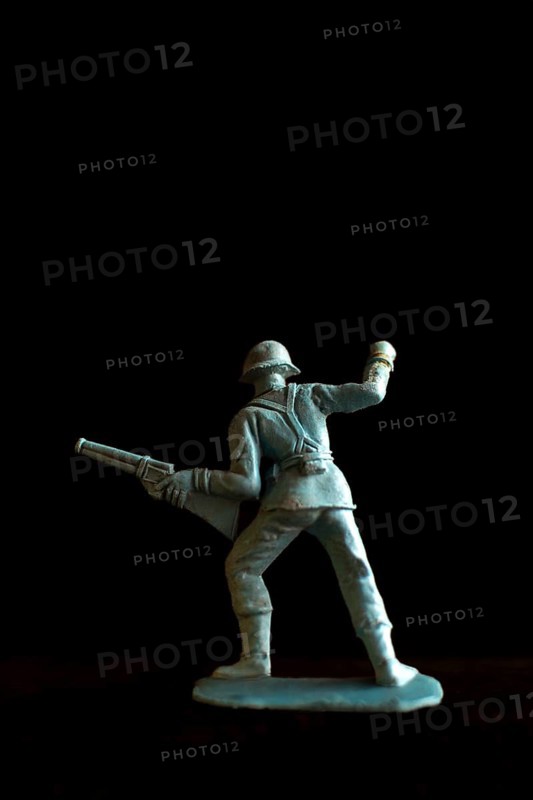 A soldier figurine stands confidently in a dynamic pose, holding a rifle pointed forward