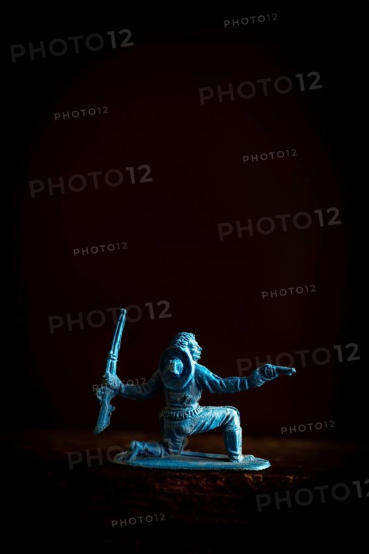A cowboy figure is captured in a low stance, dynamically poised with two weapons