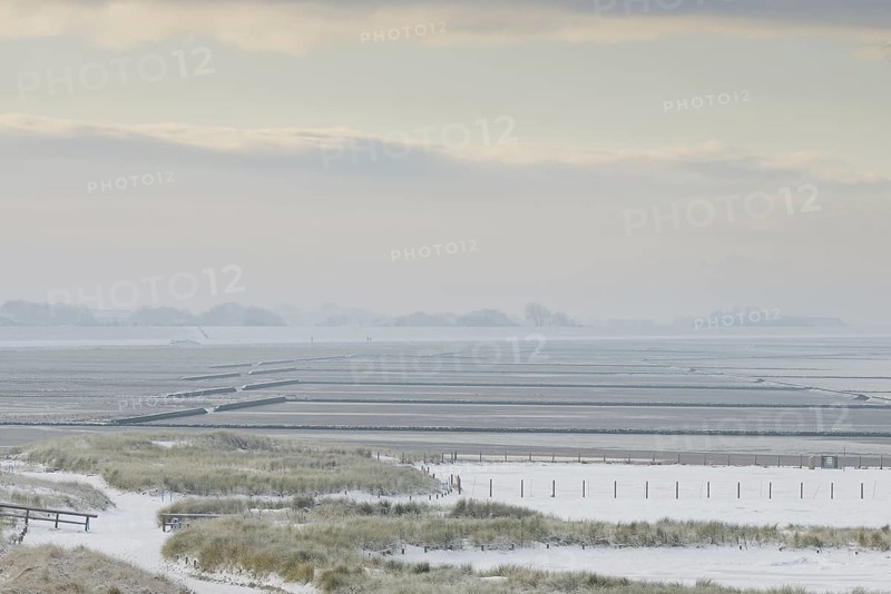 View over the snow-covered dune landscape of Norddeich, Wadden Sea at low tide, North Sea, Lower Saxony, Germany