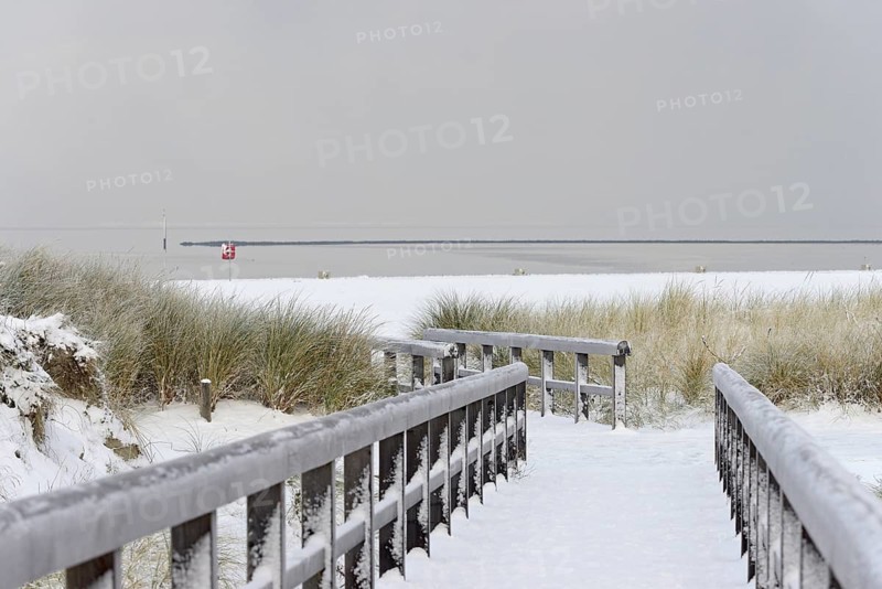 Winter day, onset of winter, wooden plank path leads through the snow-covered dune landscape to the North Sea, Norddeich, Lower Saxony, Germany