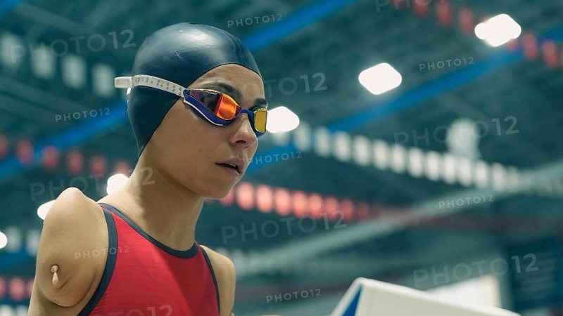 Amputee swimming in an Olympic pool