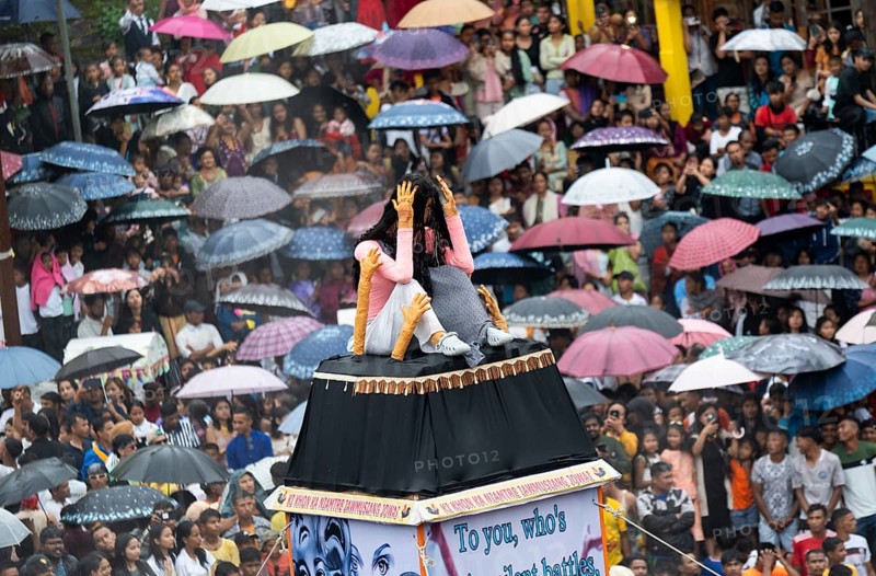 People from the Pnar community move around a Rot themed stop women harrasment as they celebrate an event organised to mark the Behdienkhlam festival in Jowai, India on July 14, 2025. Behdienkhlam is a vibrant annual festival celebrated by the Pnar (Jaintia) community of Meghalaya, especially in Jowai, to drive away plague and diseases and to pray for a good harvest. Observed in July after the sowing season, it features traditional rituals, offerings to ancestral spirits, and the grand procession of beautifully decorated bamboo structures called rots, which are later immersed in a sacred muddy pool known as Ka Aitnar