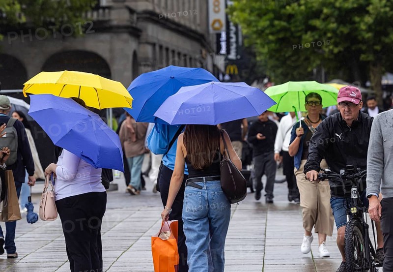 Rainy weather in Stuttgart. People with umbrellas hurry through the rain on Königstraße. Stuttgart, Baden-Württemberg, Germany