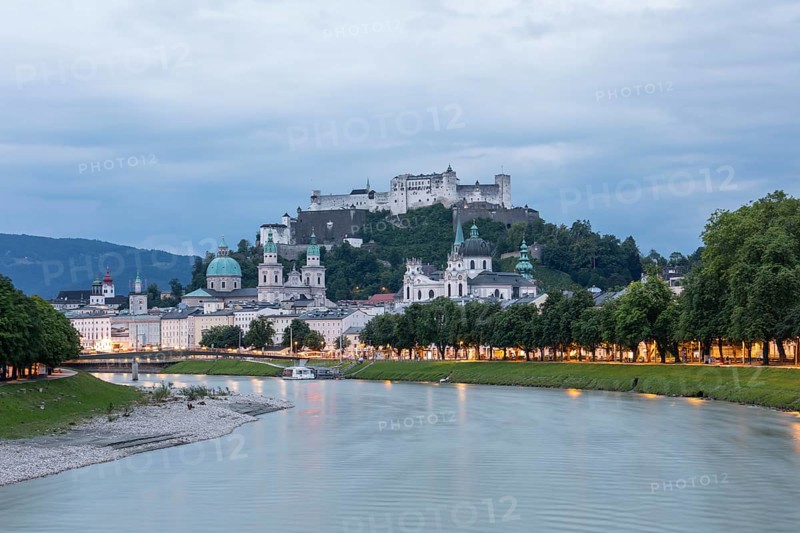 The city of Salzburg with the fortress on the Salzach shines in the first light of summer morning