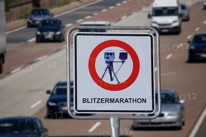 (Photomontage) Speed camera marathon Symbolic image: Sign with the inscription BLITZERMARATHON and a mobile speed trap in front of a motorway
