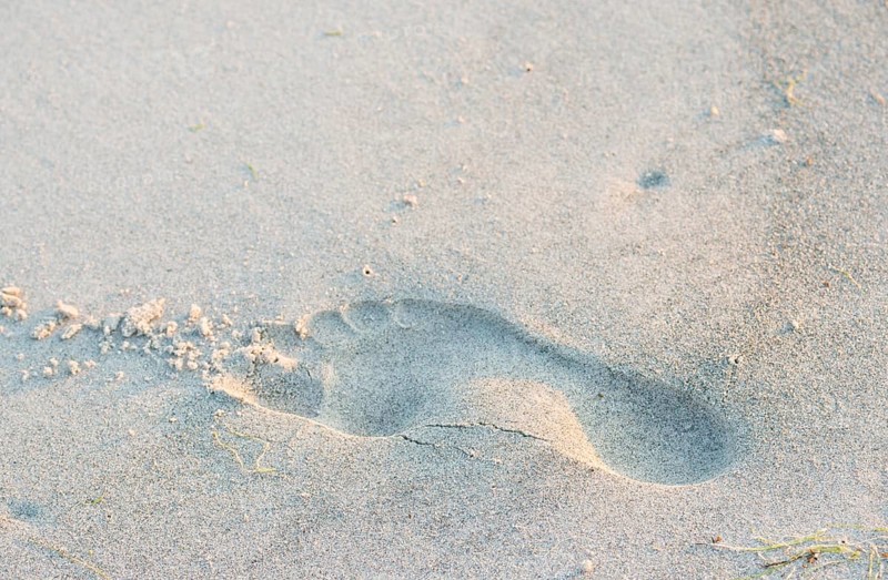 A single footprint in the sand on the beach, quiet atmosphere, warm light in the evening, human foot, trace on the sandy beach, walking, barefoot, imprint, symbolic image for one's own path, transience, leaving traces, healthy feet, health, longitudinal arch, transverse arch, toes, sole, sole of the foot, island dune, Helgoland, Schleswig-Holstein, North Sea, Germany