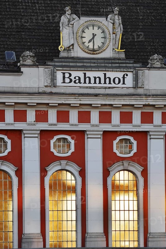 Hamm main station, façade with station clock and sculptures of a wire-drawer and a miner at the station building, North Rhine-Westphalia, Germany