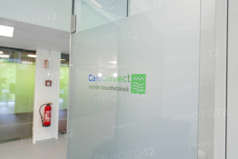 Glass wall with CareConnect logo in a modern office environment, Care Connect, vaccination kiosk for refugees, Calw, Germany
