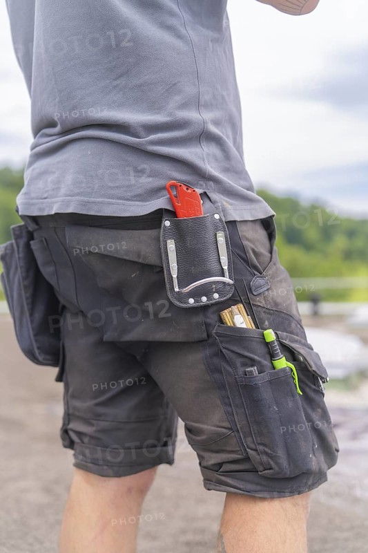 Man with tool bag outdoors, roof greening, house construction, climate neutral