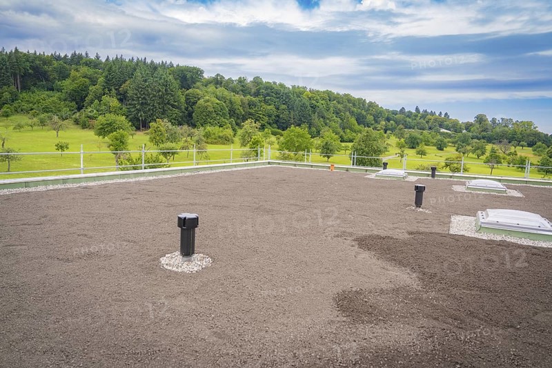 Green roof with several ventilation shafts and cloudy sky, roof greening, house construction, climate neutral