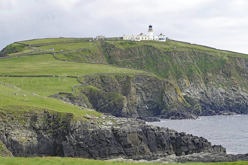 A lighthouse stands on high cliffs above a rough, cloudy coast, Sumburgh Head, Robert Louis Stevensen, Shetland Islands, Scotland, Great Britain