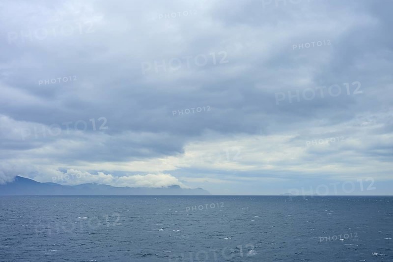 Wide sea with cloudy sky and distant mountains on the horizon, summer, Cook Strait, North Island, South Island, New Zealand