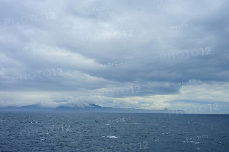 The wide sea under a cloudy sky with mountains in the distance, summer, Cook Strait, North Island, South Island, New Zealand