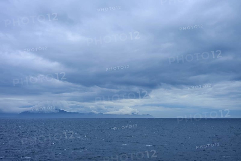 Sweeping views of the sea and distant clouds over the mountains on the horizon, summer, Cook Strait, North Island, South Island, New Zealand