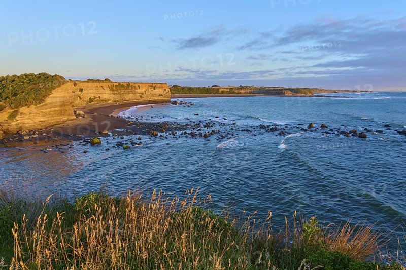 Idyllic coastal scene at sunrise with waves, beach and cliffs, summer, Opunake, Taranaki, North Island, New Zealand