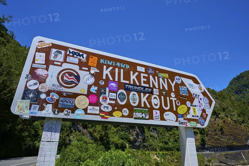 Sign at tourist lookout with various colourful stickers, Kilkenny Lookout, Lower Buller Gorge, Buller River, South Island, New Zealand