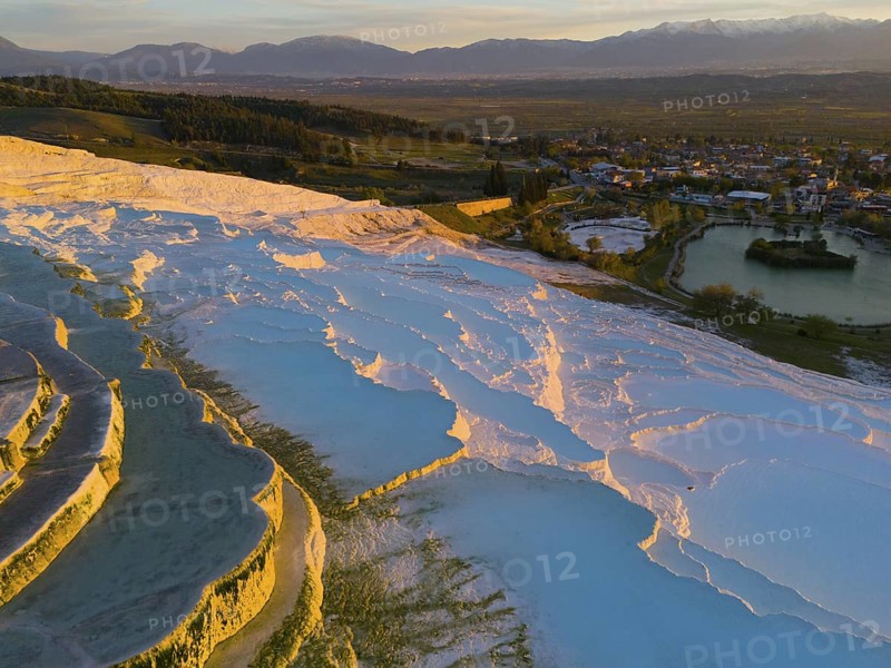 Panorama of terraces and water with mountain backdrop in the soft light of dusk, aerial view, sinter terraces, limestone sinter terraces, travertine terraces, Pamukkale, Denizli, UNESCO World Heritage Site, Anatolia, Turkey
