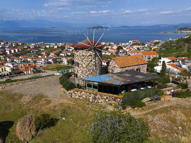 Historic windmill with sea view, surrounded by houses and green landscape, aerial view, Alibey, Alibey Adasi Island, Ayvalik, Turkey