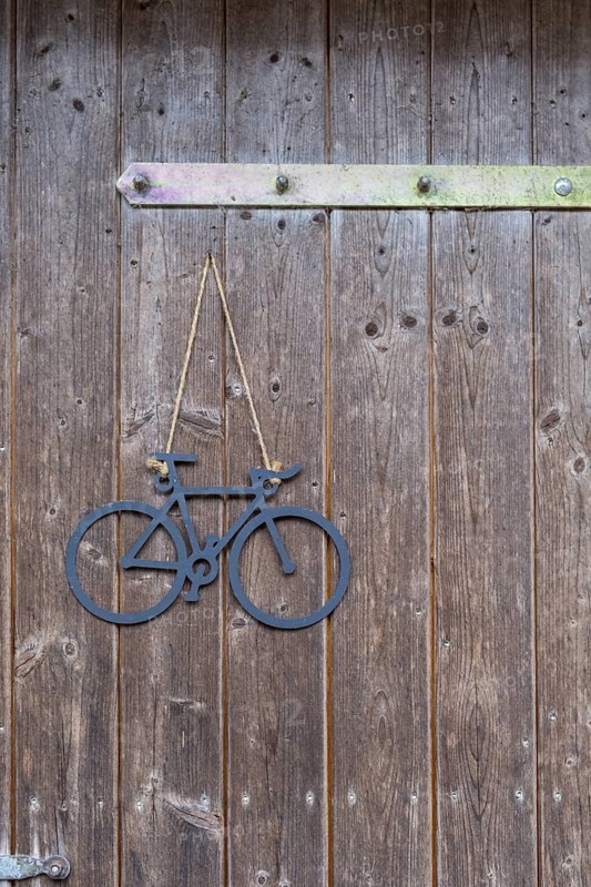 Rustic wooden door with hanging bicycle decoration on brown wood, bicycle, bicycle ornament, Germany