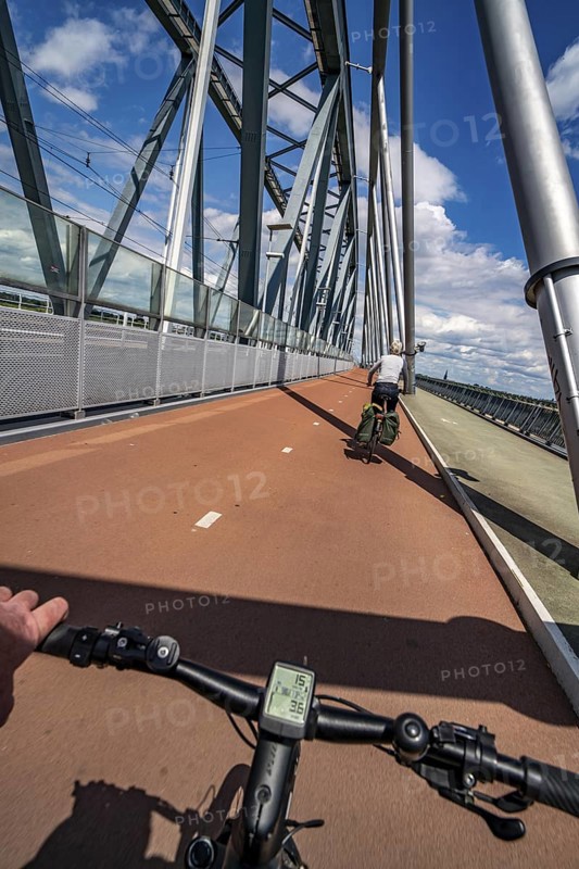 Ride over the Snelbinder Brug bicycle and pedestrian bridge, over the river Waal near Nijmegen, was built on the existing railway bridge, fast cycle path connection from the city centre of Nijmegen and the new housing estates in the Waalsprong district, Netherlands