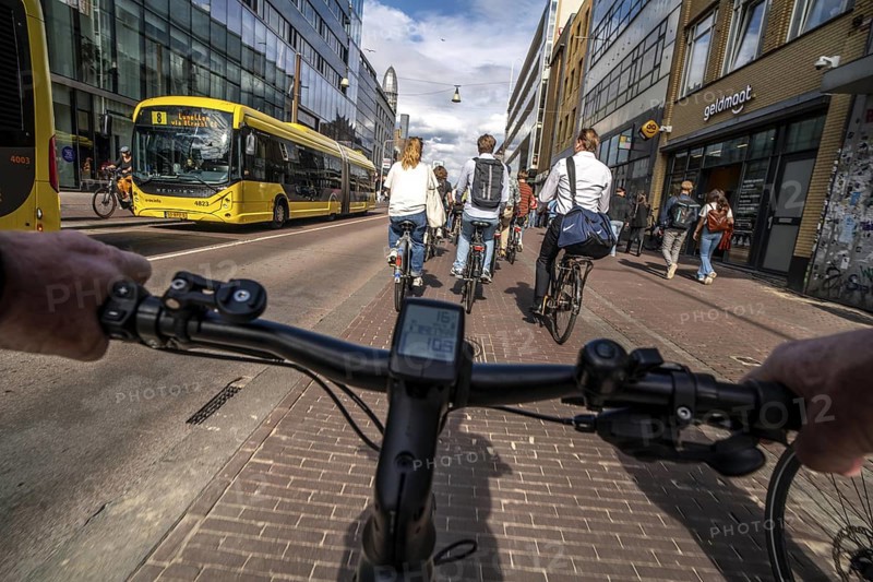 Ride your bike on the central cycle path on Lange Viestraat, Vredenburg, in the city centre of Utrecht, lanes for pedestrians, cyclists and public transport vehicles are separated, heavy cycle traffic, Netherlands