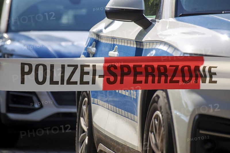 (Photomontage) Symbolic image of a police operation: police cordon in front of emergency vehicles