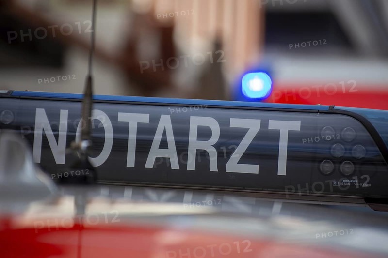 Close-up of an emergency ambulance, flashing blue lights on an ambulance in the background