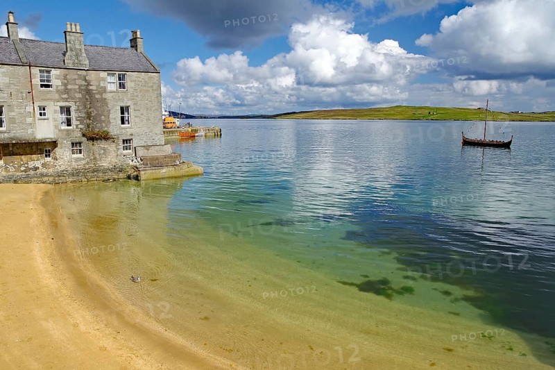 A quiet shore with an old building and a Viking ship in the water, crime series, Shetland Islands, Scotland, United Kingdom