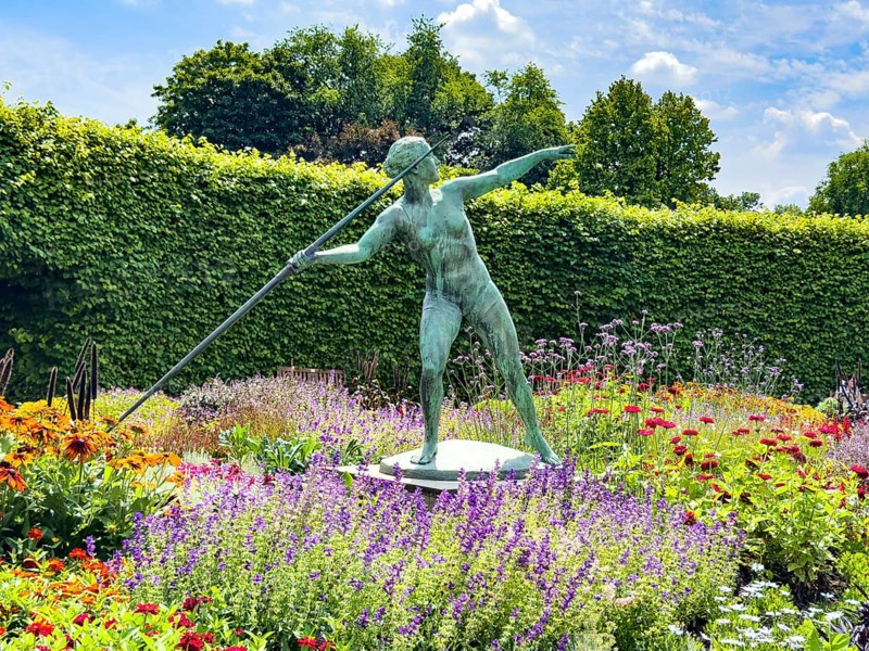 Sculpture Statue of bronze javelin thrower from 1937 by sculptor and artist Ernst Seger in flower roundabout Lindenrund in Grugapark Essen, Essen, North Rhine-Westphalia, Germany