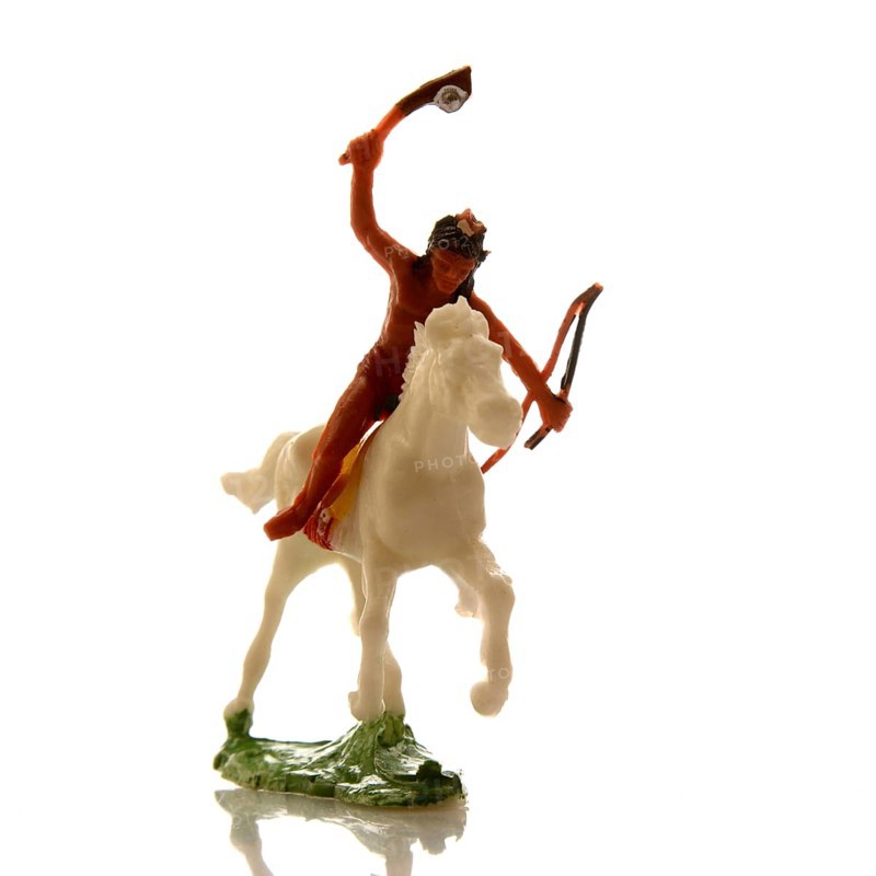 A handcrafted Indian toy soldier is captured riding a white horse with a raised bow and arrow. This colorful figure embodies traditional craftsmanship, ideal for collectors or children