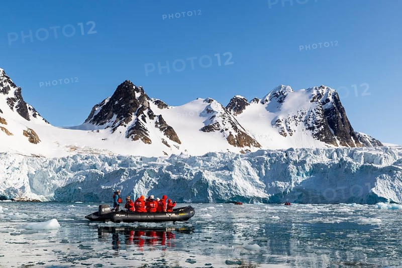 Zodiac in front of glacier and mountain range with snow, sea, Fugelfjorden, Spitsbergen, Svalbard