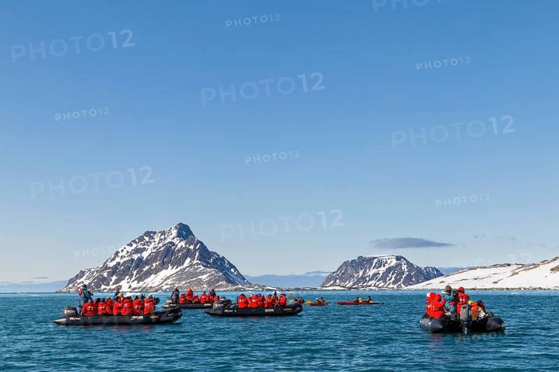 Group of Zodiacs in front of mountains with snow, sea, Fugelfjorden, Spitsbergen, Svalbard