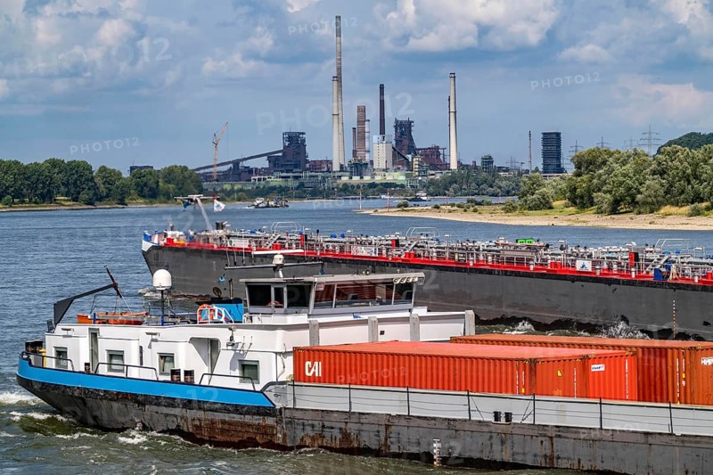 Industrial backdrop of the ThyssenKrupp Steel steelworks in Duisburg-Bruckhausen, cargo ships on the Rhine, blast furnaces, Schwelgern coking plant, Duisburg, North Rhine-Westphalia, Germany