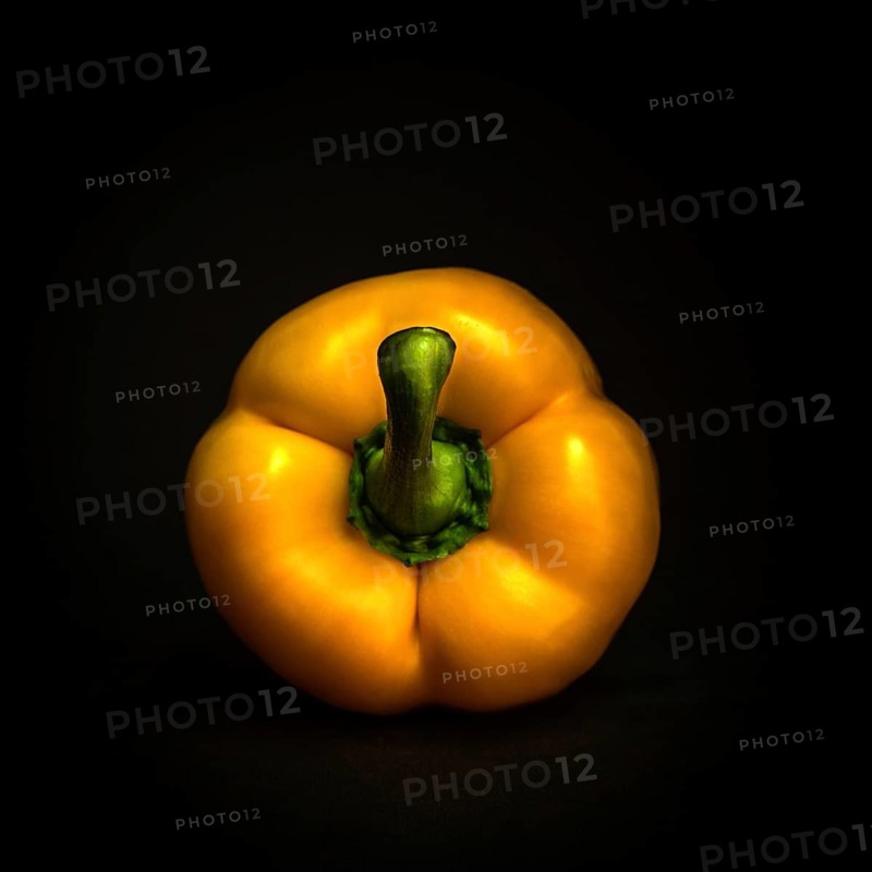 A bright yellow bell pepper showcases its glossy skin with a green stem, beautifully contrasting against a deep black backdrop. This vibrant vegetable exudes freshness and healthiness
