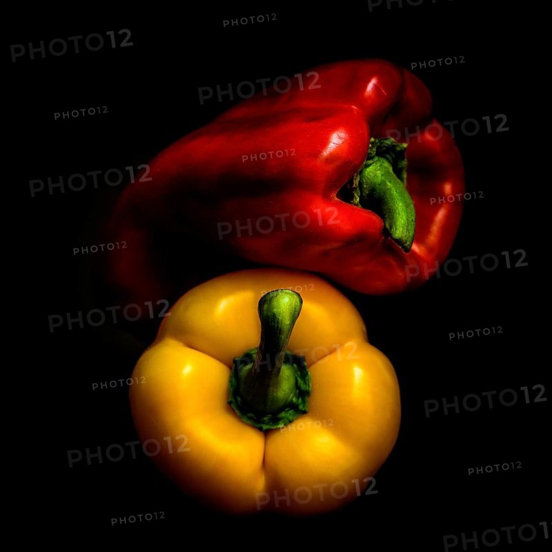 Red and yellow bell peppers are arranged prominently on a black background, highlighting their glossy surfaces and distinctive shapes