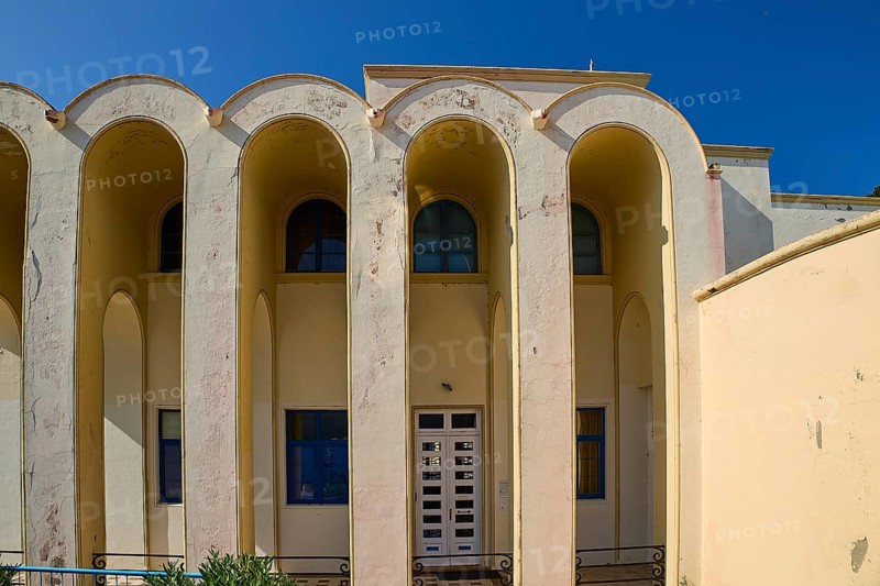 Primary school, Beige-coloured building with arches and windows under a blue sky, Armando Bernabiti, Historicism, Rationalism, Art Deco, Rationalism, Rodolfo Petraco, Fascism, Portolago, Lakki, Leros, Dodecanese, Greek Islands, Greece