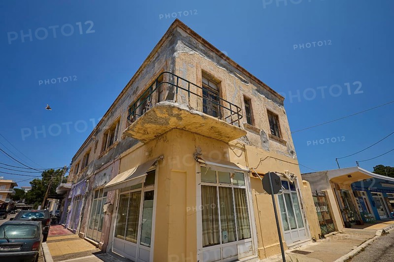 Persiana, Old building with worn façade and small balcony on a street corner, Armando Bernabiti, Historicism, Rationalism, Art Deco, Rationalism, Rodolfo Petraco, Fascism, Portolago, Lakki, Leros, Dodecanese, Greek Islands, Greece