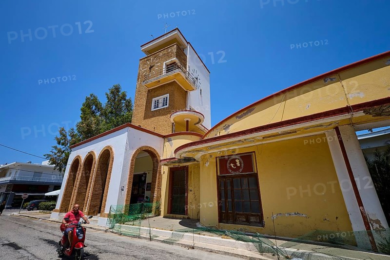 Market hall, Agora, Historical building with clock tower and arches, animated by people and trees along a street, Armando Bernabiti, Historicism, Rationalism, Art Deco, Rationalism, Rodolfo Petraco, Fascism, Portolago, Lakki, Leros, Dodecanese, Greek Islands, Greece