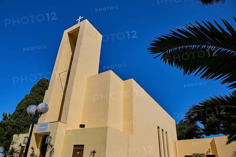 Church of Saint Francis, Church of Saint Nicholas, Agios Nikolaos, Modern church with cross and framed by palm trees against a clear sky, Armando Bernabiti, Historicism, Rationalism, Art Deco, Rationalism, Rodolfo Petraco, Fascism, Portolago, Lakki, Leros, Dodecanese, Greek Islands, Greece