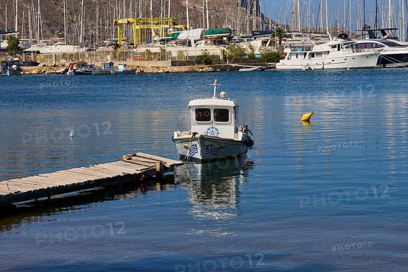 Small boat at the pier in a picturesque harbour with sailing yachts in the background, Lakki, Leros, Dodecanese, Greek Islands, Greece