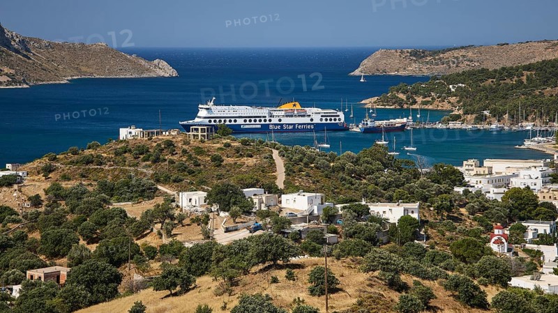 Large ferry in front of a coastal settlement on a hill with blue sea in the background, Lakki, Leros, Dodecanese, Greek Islands, Greece