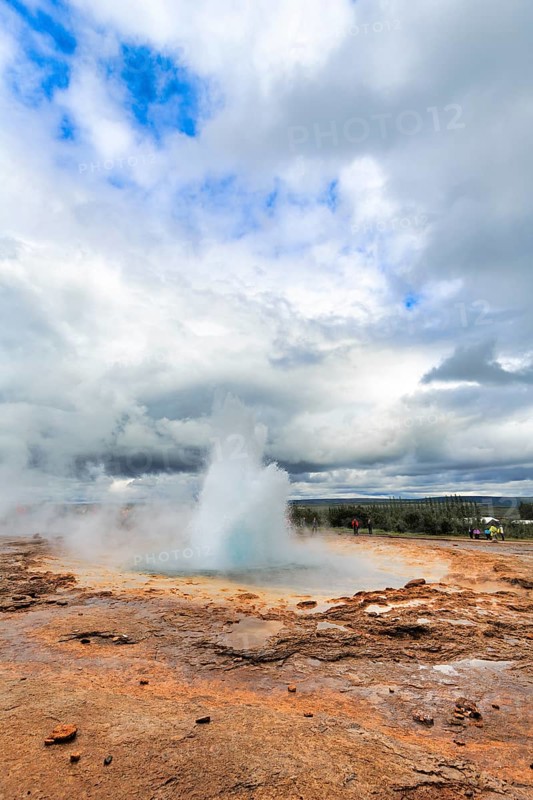 Active Strokkur, tourists watch eruption, high temperature area Haukadalur, tourist attraction at the Golden Circle, Sudurland, Iceland